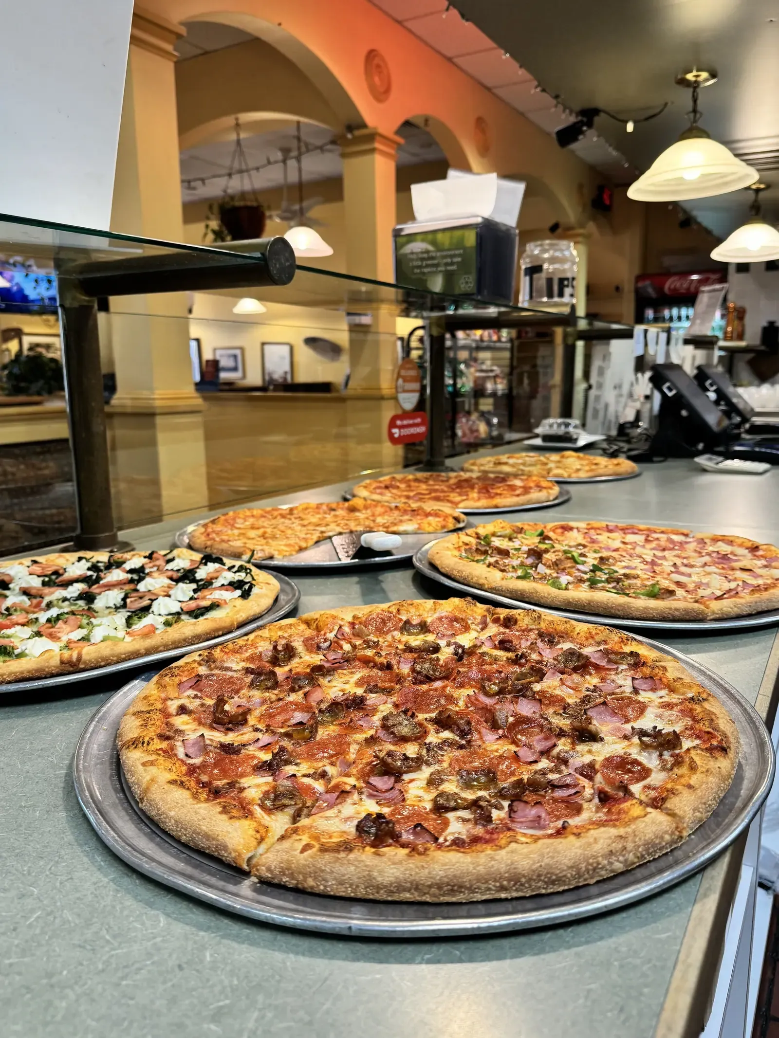 A spread of pizza, pasta and salads on the table at Rudy's